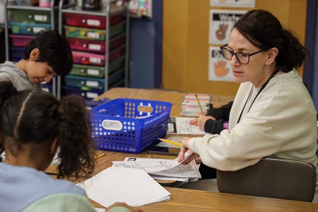 image of teacher working with elementary students