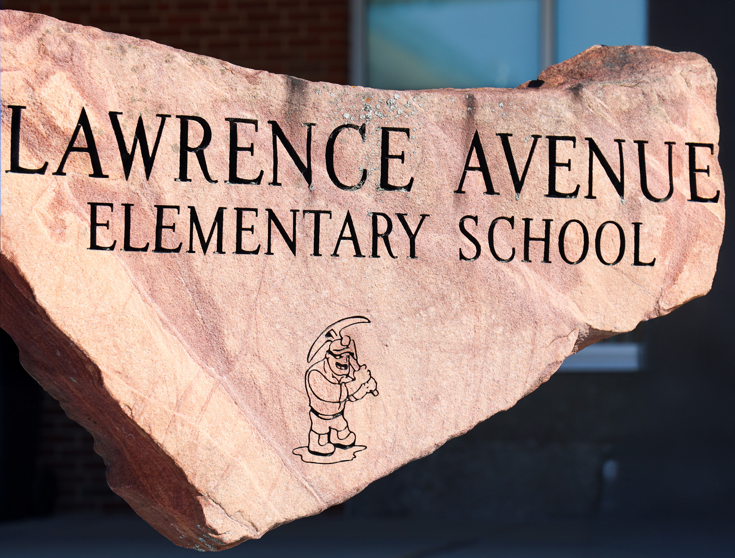 image of Lawrence Avenue Elementary School rock with Sandstoner mascot carving.