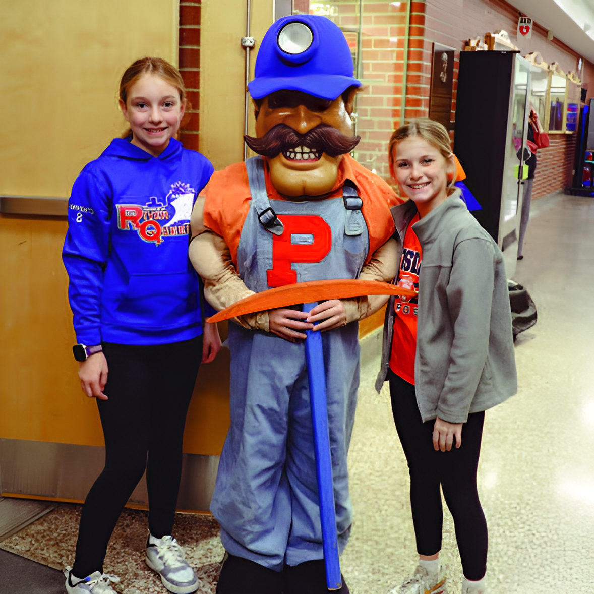 students smile with the district's Sandstoner mascot