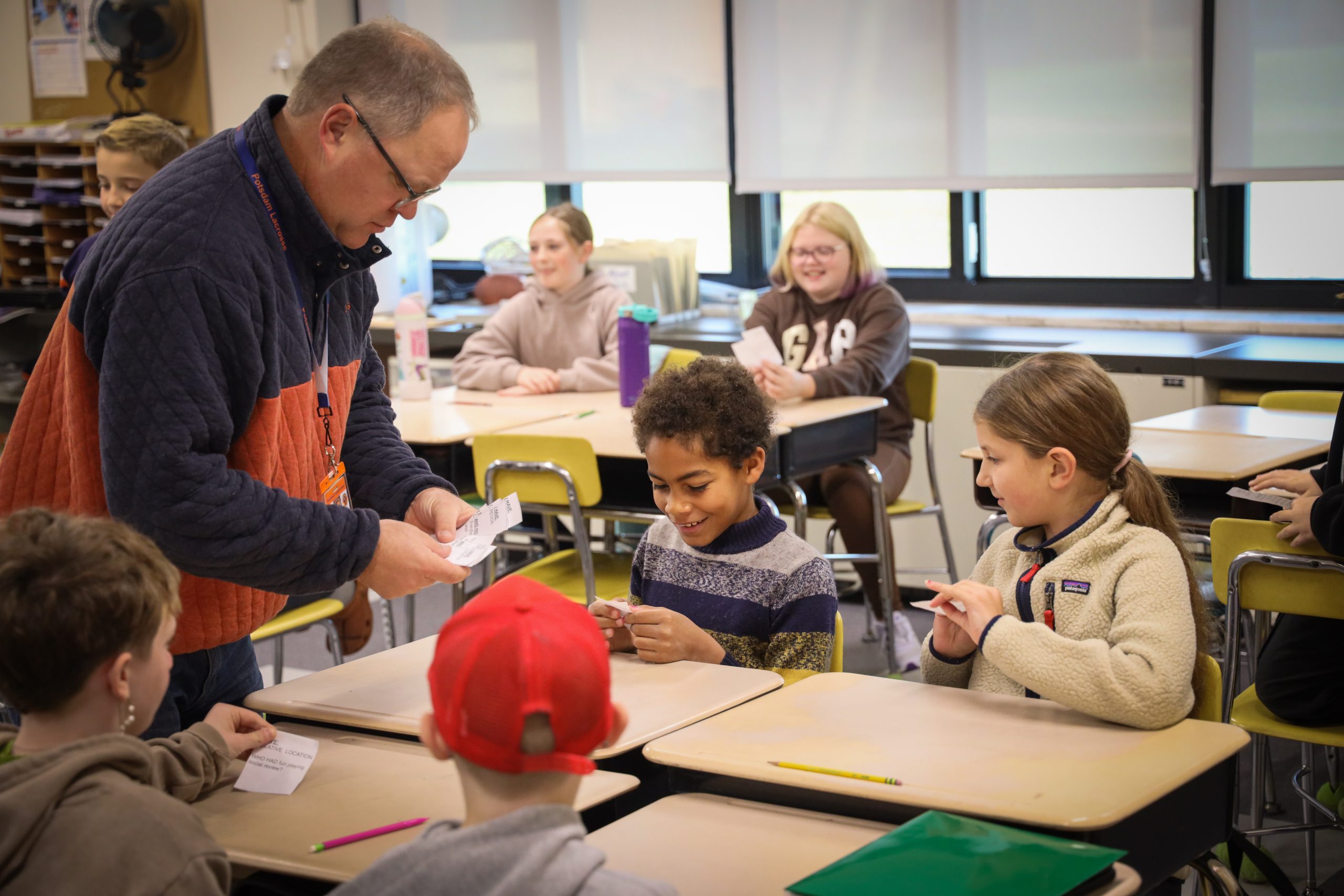 Teacher hands out activity to students in class 
