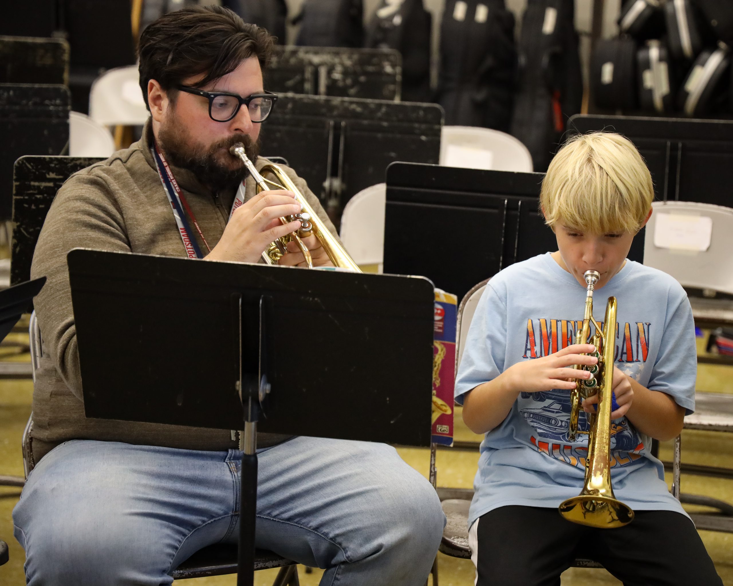 Band Instructor and middle school student sit and practice Trumpet in a lesson 