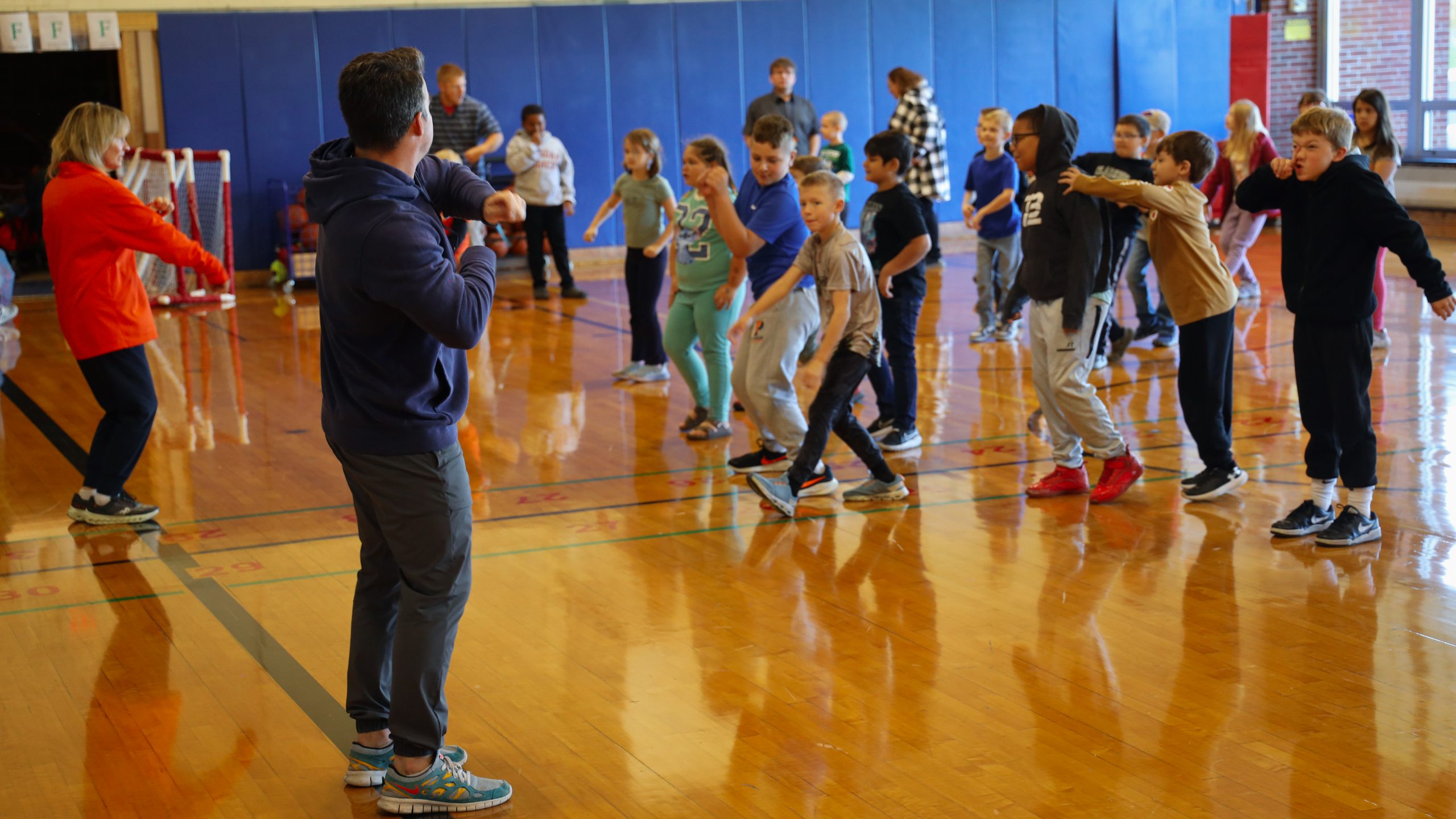Gym teachers lead class of elementary students through class