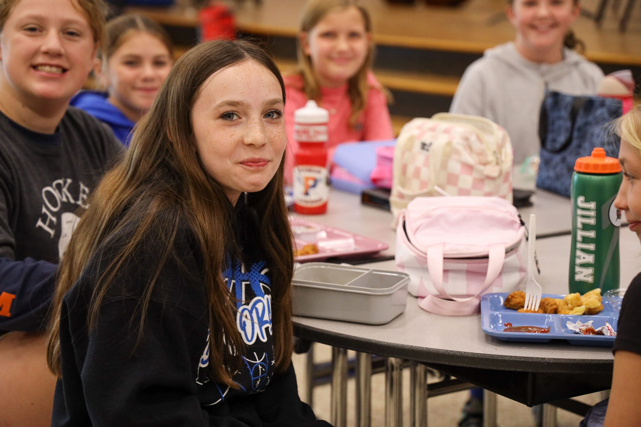 Group of friend smile at the camera during their lunch break in the cafeteria 