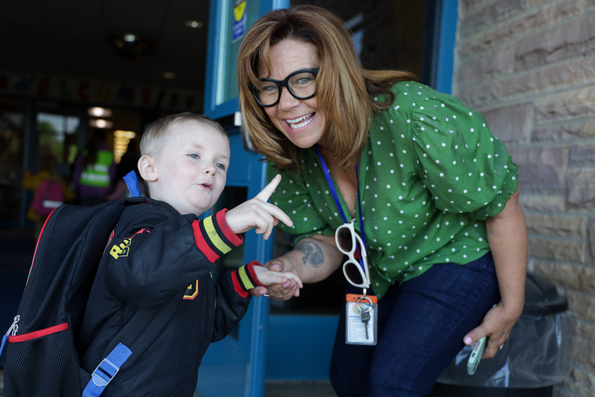 Elementary teacher and boy smile for photo