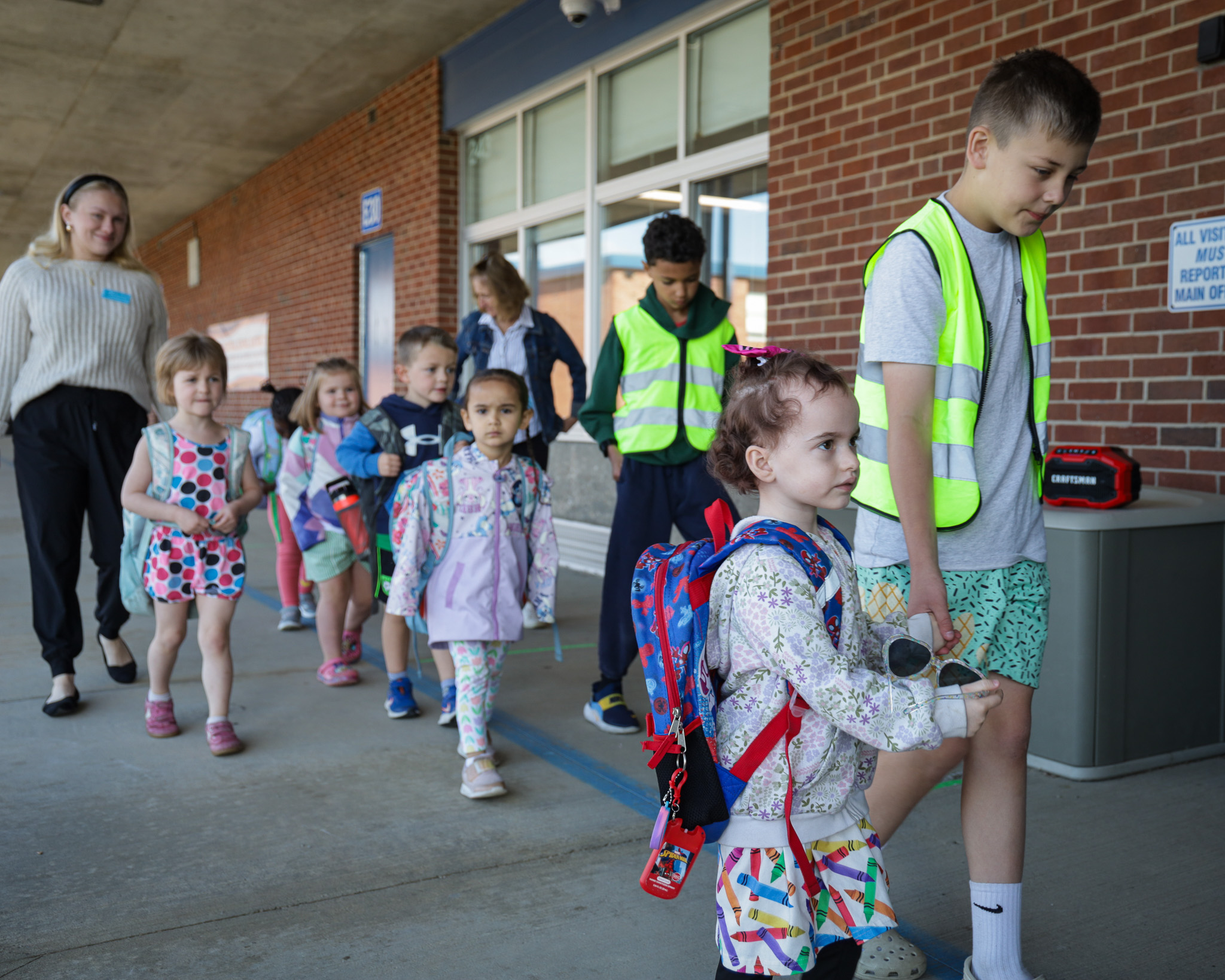 Elemenatry students hold hands with crossing guards 