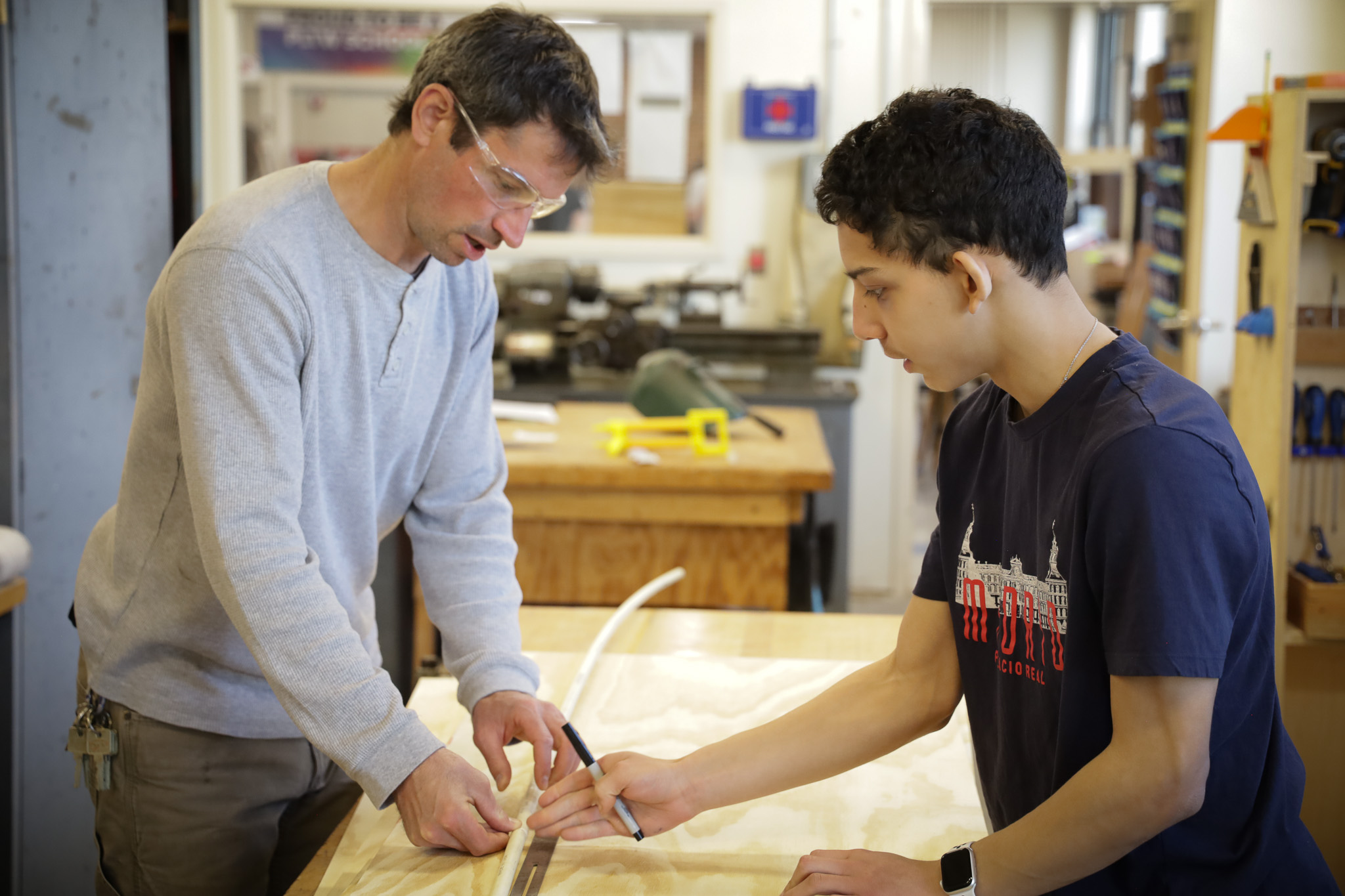High school student and teacher work in shop classs